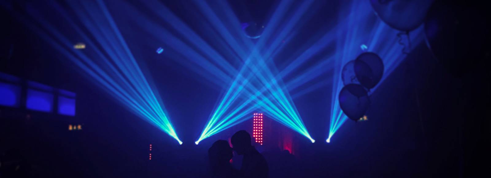 Blue moving-head beams over a dance floor